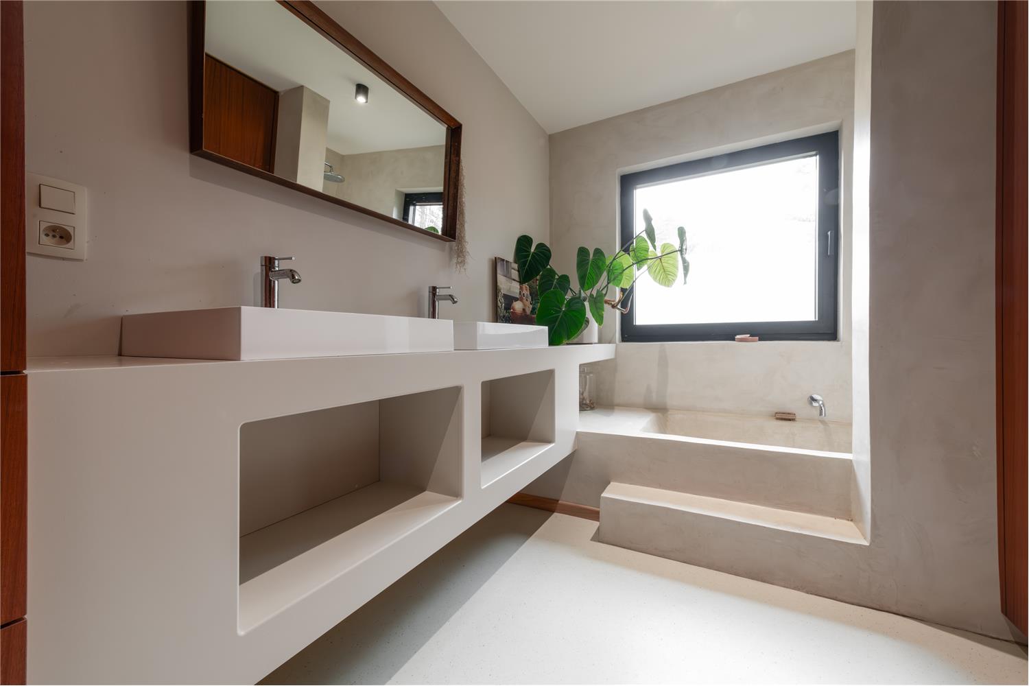 Badkamer op maat met bad, dubbele wastafel en slimme indeling die rust en functionaliteit combineert