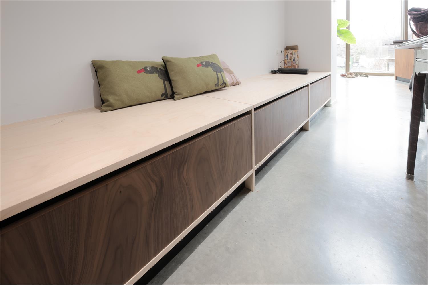 Maatkasten in de vorm van een zitbank met geïntegreerde opbergruimte, perfect afgestemd op het interieur