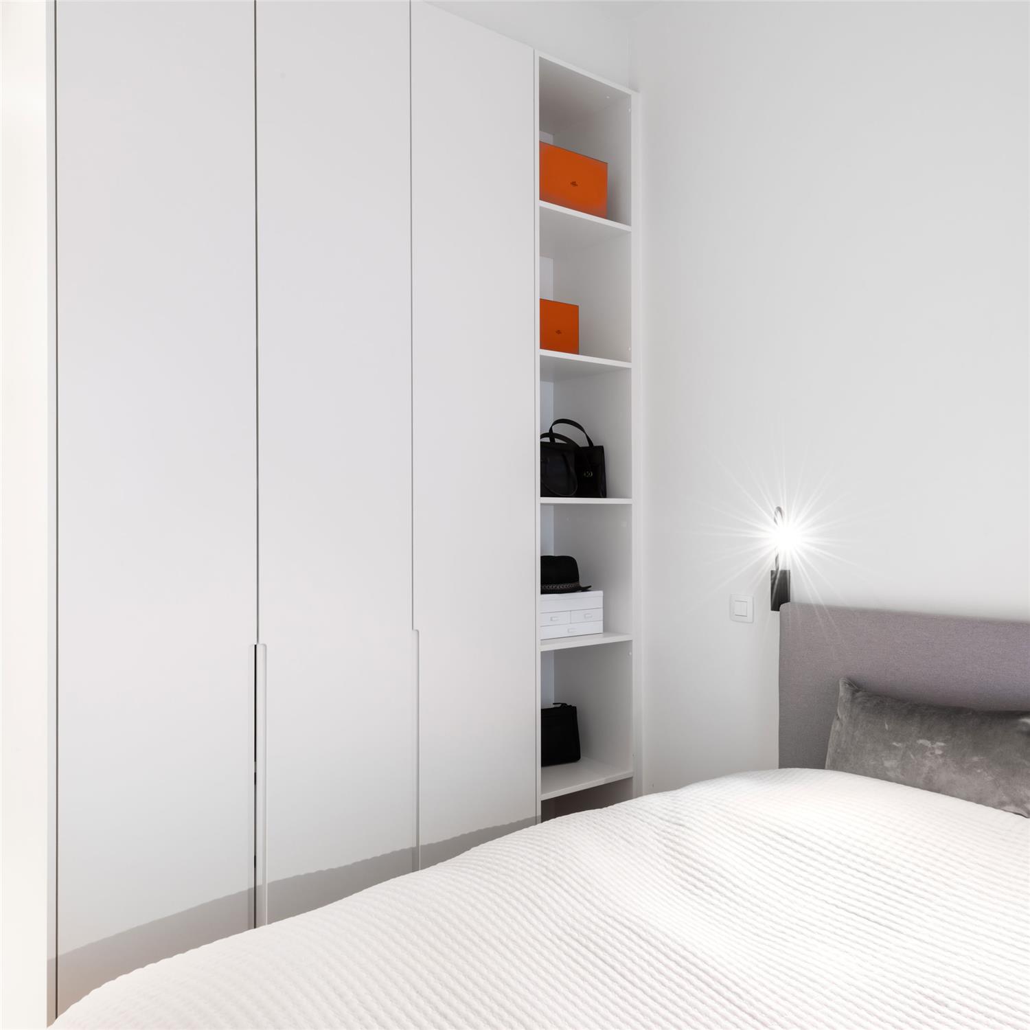 Slimme indeling van een slaapkamer op maat met ingebouwde kasten en open vakken voor extra opbergruimte