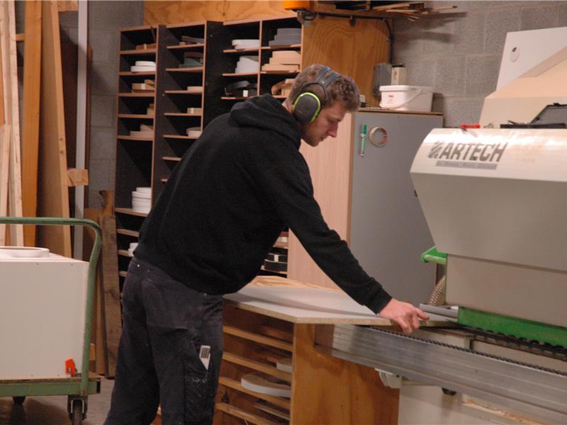 Medewerker van Interieur Van Gool bewerkt plaatmateriaal in het atelier